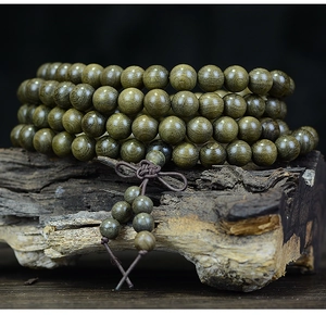 Detailed macro view of 108 Phoebe zhennan wood beads with natural texture on wood base