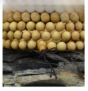 Macro shot of 108 Thuja beads showing natural wood grain texture on aged bark