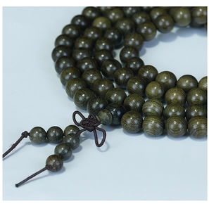 Close-up of 108 dark wood Buddhist prayer beads showing rich texture and grain