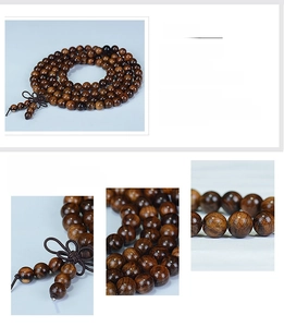 Macro shot of polished 108 black rosewood prayer beads showing natural wood grain texture