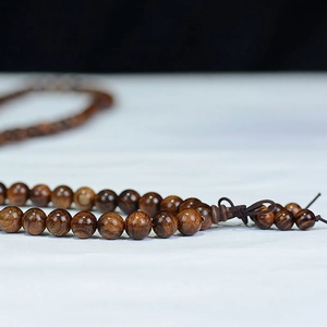Polished Black Rosewood 108-bead prayer bracelet with natural wood grain and traditional knot