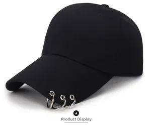 Detail view of black baseball cap featuring three silver metal rings on the brim