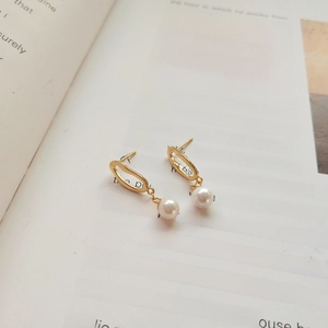 Detailed view of elegant gold irregular pearl earrings on a vintage book page