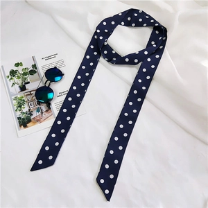 Close-up of long navy blue polka dot silk scarf with sunglasses and fashion magazine