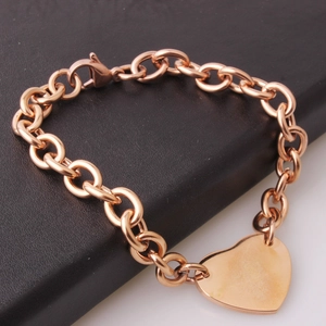 Macro shot of rose gold stainless steel link chain bracelet with polished heart pendant