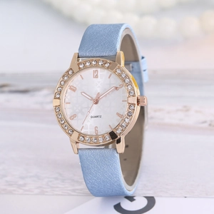 Detail of light blue leather strap watch with rhinestone bezel and clover dial