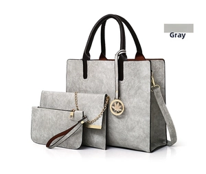 Detailed view of gray PU leather 3-piece bag set with gold hardware and maple leaf charm