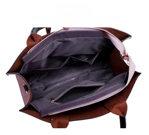 Detail view of the interior with two slip pockets and a zip pocket in a brown handbag