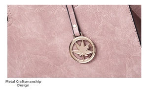 Detail of pink PU leather tote featuring fine stitching and gold maple leaf pendant