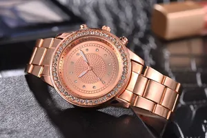 Detailed side view of a rose gold quartz watch with rhinestone bezel and metal chain strap