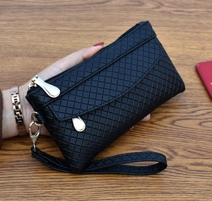 Detail of black quilted leather handbag with gold zipper and stylish metal puller