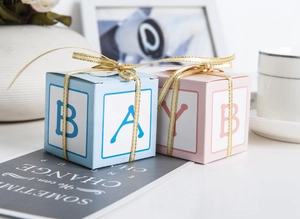 Close-up of pastel gift boxes with golden ribbons and letter motifs for baby showers