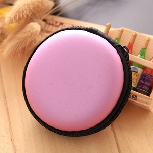 Pink EVA circular mini coin purse and headphone organizer case on wooden desk