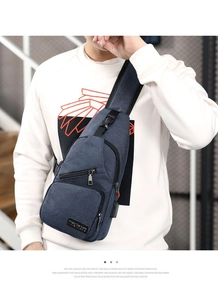 Detail view of navy blue nylon chest bag with USB port and multiple zipper pockets