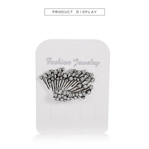 Detail shot of vintage silver fan-shaped earring with crystals on fashion display card