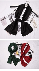 Flat lay of silk-like neck scarves in black, dark green and burgundy with stylish accessories