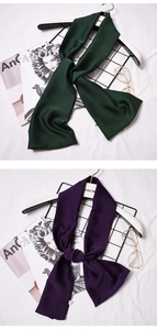 Detail showing dark green and deep purple silk scarves with subtle glossy texture