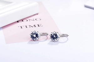 Detailed macro view of silver hoop earrings featuring a large round zircon with prong setting