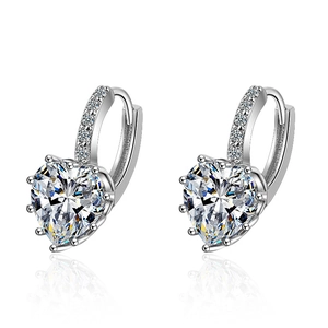 Silver hoop earrings with heart-cut cubic zirconia and pavé stones on white background
