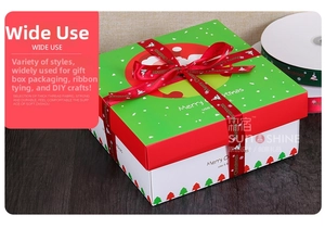 Detail of red Merry Christmas ribbon on a festive gift box with tree patterns