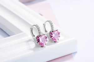 Detail of silver heart hoop earring with pink zircon stone and pavé crystal accents