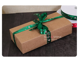 Detail of red and green Merry Christmas satin ribbons on a kraft paper gift box
