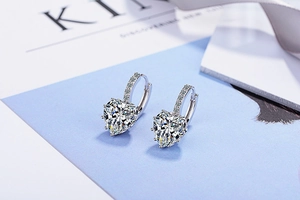 Detailed close-up of silver heart-shaped earrings with sparkling cubic zirconia pavé setting