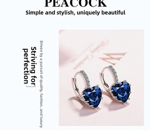 Macro detail of heart-shaped dark blue zircon earring with silver diamond-set hook
