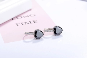 Macro shot of silver heart earrings with black gems and micro-pave zirconia crystals