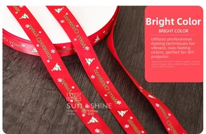 Red Christmas ribbon with snowflake patterns on dark wooden background for gift wrapping