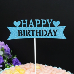 Close-up of blue glittery Happy Birthday cake topper with heart motifs and marshmallow decor