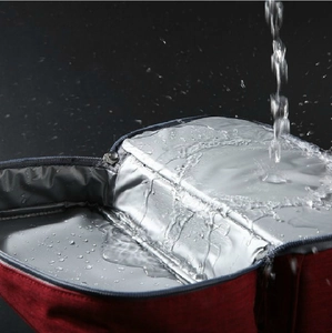 Waterproof red insulated lunch bag showing silver leak-proof inner lining and zipper