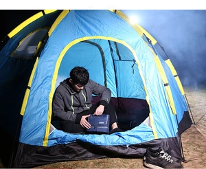 Close-up of navy blue waterproof toiletry bag held inside a tent for travel storage