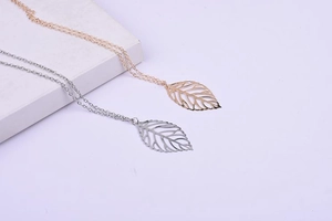Detailed view of hollow leaf pendant necklaces in gold and silver finish with metal shine
