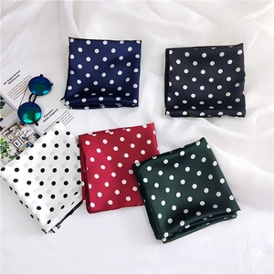 Detailed view of polka dot satin scarves in five colors on a chic fashion magazine