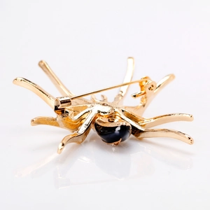 Golden spider insect brooch featuring a black teardrop gemstone and secure pin clasp