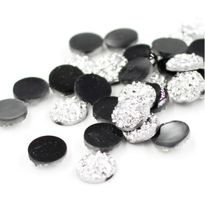 Macro view of 8mm round resin druzy stones with black and silver stardust texture