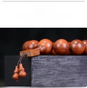Makro-Detail von Birmanischem Padauk-Gebetsperlen mit natürlicher Maserung und Anhängern