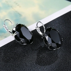 Detail shot of silver earrings with large oval black cubic zirconia in French hooks