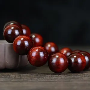 Polished dark reddish-brown wood bead bracelet with natural grain and glossy finish