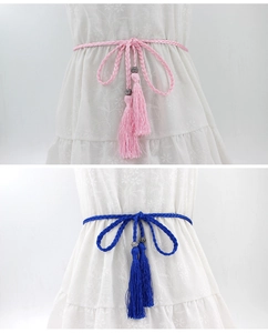 Close-up of pink and navy woven waist ropes with tassels and silver beads details