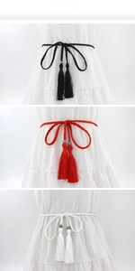 Detailed view of woven rope belts in black, red, and white with ethnic fringe and beads