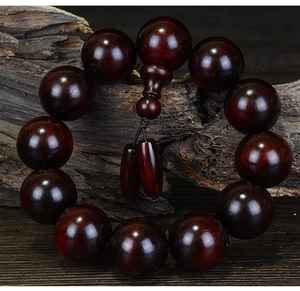 Macro shot of polished red sandalwood prayer beads showing natural wood grain and texture