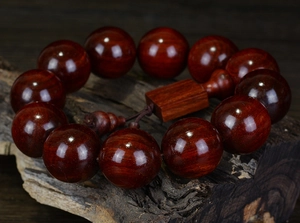 Macro shot of polished red sandalwood Buddhist prayer beads with fine wood grain