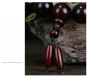 Close-up of polished dark red sandalwood prayer beads with two oval pendant beads