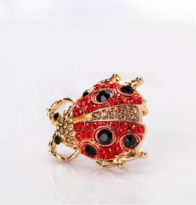 Macro shot of ladybug brooch featuring red rhinestones and golden metal details