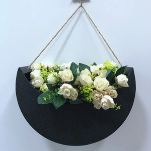 Wall-mounted black semi-circle flower pot with white roses and natural hemp rope