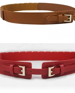 Detail of elegant slim elastic waist belts with metal buckles in brown and red colors