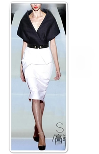 Detail of slim black elastic waist belt with gold metal interlocking buckle on dress