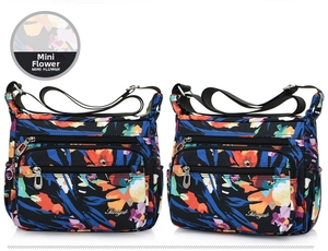 Detail of multi-pocket nylon shoulder bag with colorful mini flower print and adjustable strap